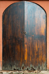 Ancient closed wooden door on a red wall in a taoist temple, Luodai, Sichuan province, China - 574854674