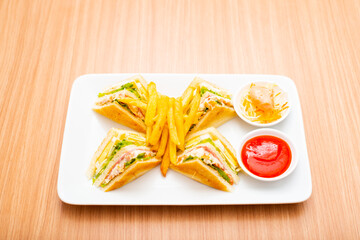 A Serving of club sandwich served with side of fries