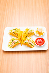 A Serving of club sandwich served with side of fries