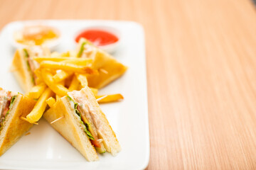 A Serving of club sandwich served with side of fries