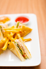A Serving of club sandwich served with side of fries