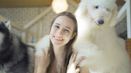 Portrait of caucasian woman girl playing with dogs or puppy smiling in cafe restaurant. Pet animal. People lifestyle.