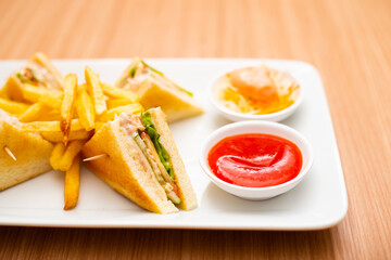 A Serving of club sandwich served with side of fries
