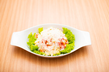A Serving of healthy salad topped with mayonaise