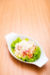 A Serving of healthy salad topped with mayonaise