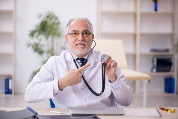 Old male doctor working in the clinic