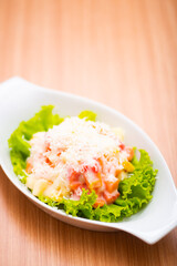 A Serving of healthy salad topped with mayonaise