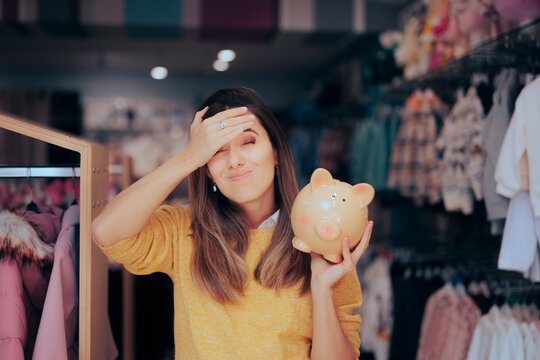 Frustrated Customer Holding a Piggy Bank in a Fashion Store. Unhappy woman suffering from buyer remorse after shopping spree

