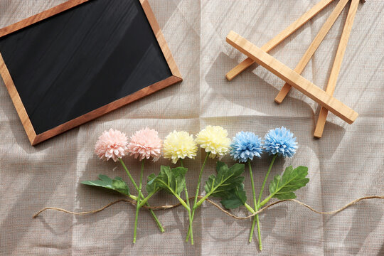 コピースペースのあるブラックボードとパステルカラーの花のウェルカムボードイメージ