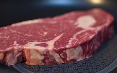 piece  beef raw meat entrecote lies in a frying pan