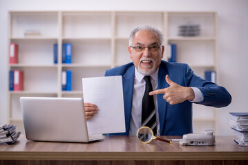 Obraz premium Old male employee working in the office