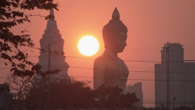 Evening sunset behind the Giant Buddha Statue at Wat Paknam Phasi Charoen in Bangkok, Thailand.