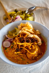 Khao Soi,Khao Soi Kai, Thai Noodles Khao Soi, Chicken Curry 
with seasoning on wooden floor, Northern Thai food concept. (Lanna food)