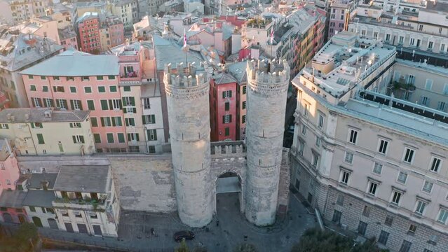 Drone tilt-up reveal of Porta Soprana (towered gate) in heart of Genoa, Italy