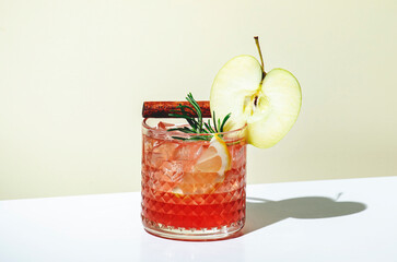 Apple pie alcoholic cocktail drink with vodka, apple liqueur, cinnamon, lemon, garnished with...