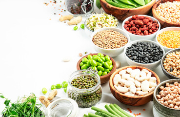 Legumes and beans. Dried, raw and fresh. Lentils, chickpeas, mung beans, soybeans, edamame, peas in glass jars. Healthy diet food, vegan protein, micronutrients and fiber sources. White kitchen