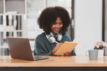 Young black African woman university student learning online using laptop computer. Smiling girl watch webinar or virtual education.