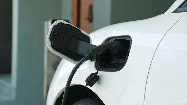 Home charging station providing sustainable, renewable source of power for electronic vehicle, EV cars at home for progressive modern lifestyle. Eco-friendly hybrid electro and petrol vehicle battery.