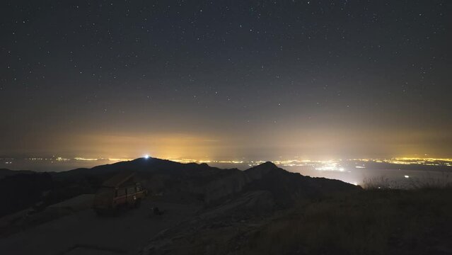 Timelapse camper van top mountain stars night city lights Thasos Greece