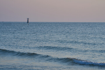 Fototapeta premium wave with blur floating lighthouses in the sea on blur sky background