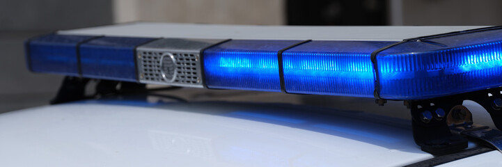 Blue lights on roof of police car in city