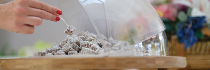 Hand selection of Turkish delight with coconut and pistachios on table.