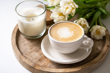 White tulips and a cup of coffee on a wooden tray. Women's day greeting card