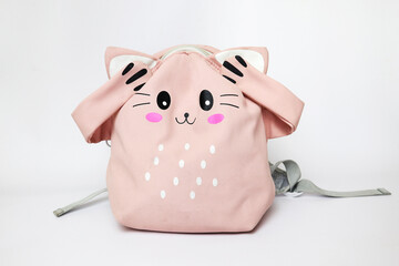 closed ears of a schoolgirl. pink backpack with emotion. problems at school