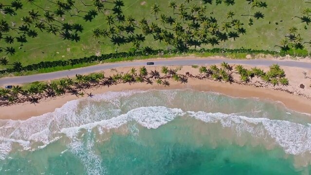 Car driving along exotic and panoramic road, Arroyo Salado beach, Cabrera in Dominican Republic. Aerial top-down sideways