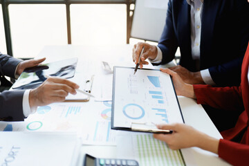 Team business adviser meeting to analyze and discuss the situation on the financial report n the meeting room with using calculator, documents, computer laptop in work.