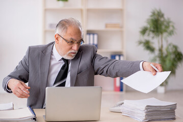 Old male employee working in the office