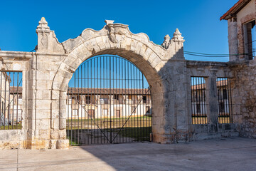 Fototapeta na wymiar Architectural stone arch that gives entrance to the courtyard of buildings in the monumental area of Nuevo Baztan, Madrid.