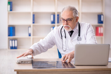 Old male doctor radiologist working in the clinic