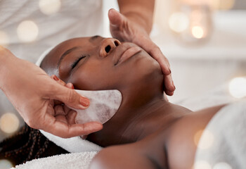 Obraz na płótnie Canvas Black woman, gua sha massage and luxury face treatment of a young female with spa facial. Skincare, rose quartz tool and beauty in wellness clinic with client feeling calm and zen from dermatology