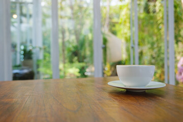 Closeup image of a cup of hot coffee on wooden table in cafe