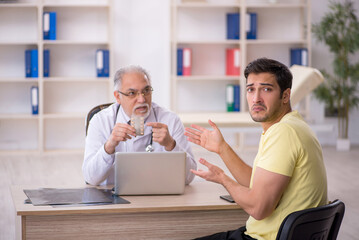 Young male patient visiting old male doctor
