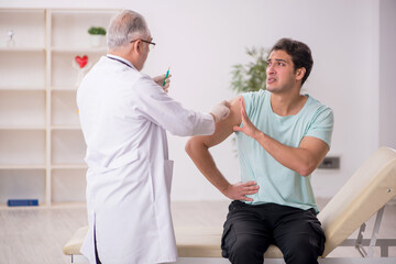 Young male patient visiting old male doctor in vaccination conce