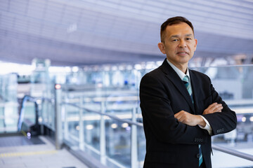 Fototapeta premium Asian middle-class businessman heading for an overseas business trip in the airport lobby.