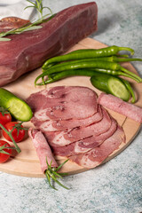 Smoked beef tongue. Sliced Smoked Veal Tongue on Wooden Cutting Board. Delicious smoked meat. Local name fume dana dil