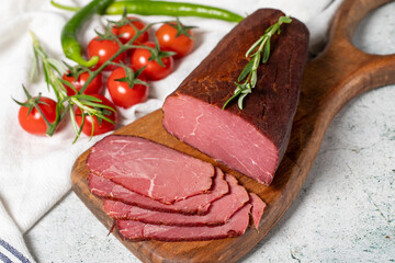 Dry meat. Slices of dried and smoked dry meat on a wooden board. Beef jerky pieces