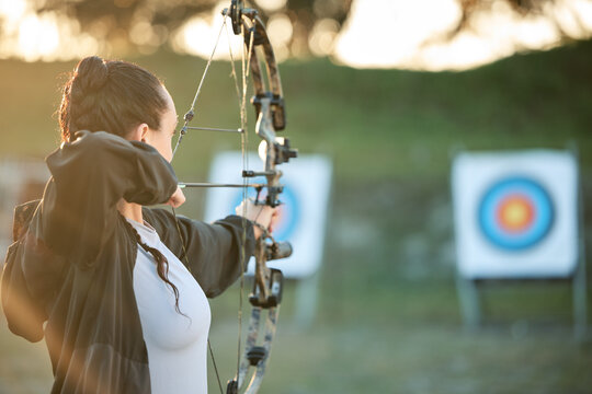 Sports archer, target and bow and arrow training for archery competition, athlete challenge or girl field practice. Shooting, objective and competitive woman focus on precision, aim or mock up