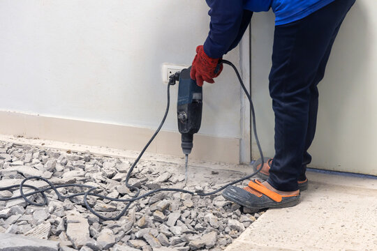 Labor using jack-hammer drilling on the floor. Construction working industry tools for repair or renovation in site construction.