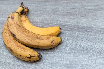 Spotted bananas. Close-up of bunch with overripe bananas on wooden board