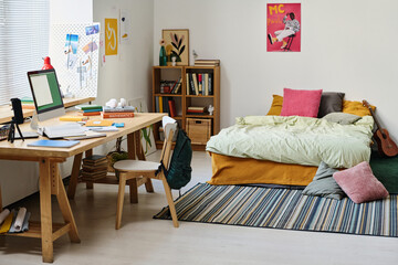 Horizontal image of modern bedroom of teenager with desk with computer monitor on it