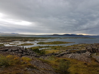 Fototapeta na wymiar Lake view with mountains in the horizon on a cloudy day at Thingvellir National Park in Iceland