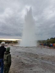 Obraz premium Tourists watching the geyser Strokkur erupt in Iceland
