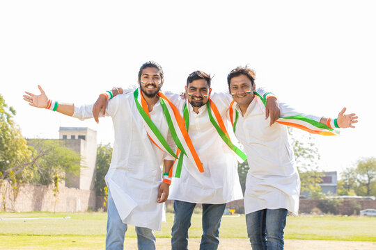 Group of cheerful young men wearing traditional white kurta and tricolor duppata with face painted celebrating independence day or republic day. 15th august, 26 January.