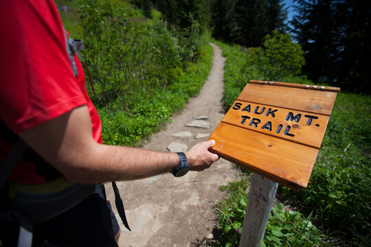 A hiker reaches for the registry kiosk at the Sauk Mountain Trailhead