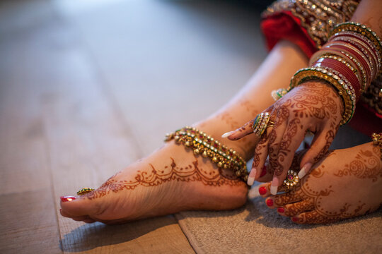 Jewelry is worn over the henna covered hands and feet of an Indian woman.