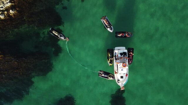 A man flies on a FlyBoard. Aerial top down view. Water extreme sport, azure summer sea with outdoors active people enjoying water sports. Flyboarding and seariding, Recreation and sports concepts.